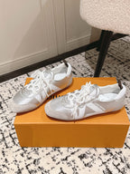 Louis Vuitton metallic silver low-top sneakers with white laces, side-by-side view