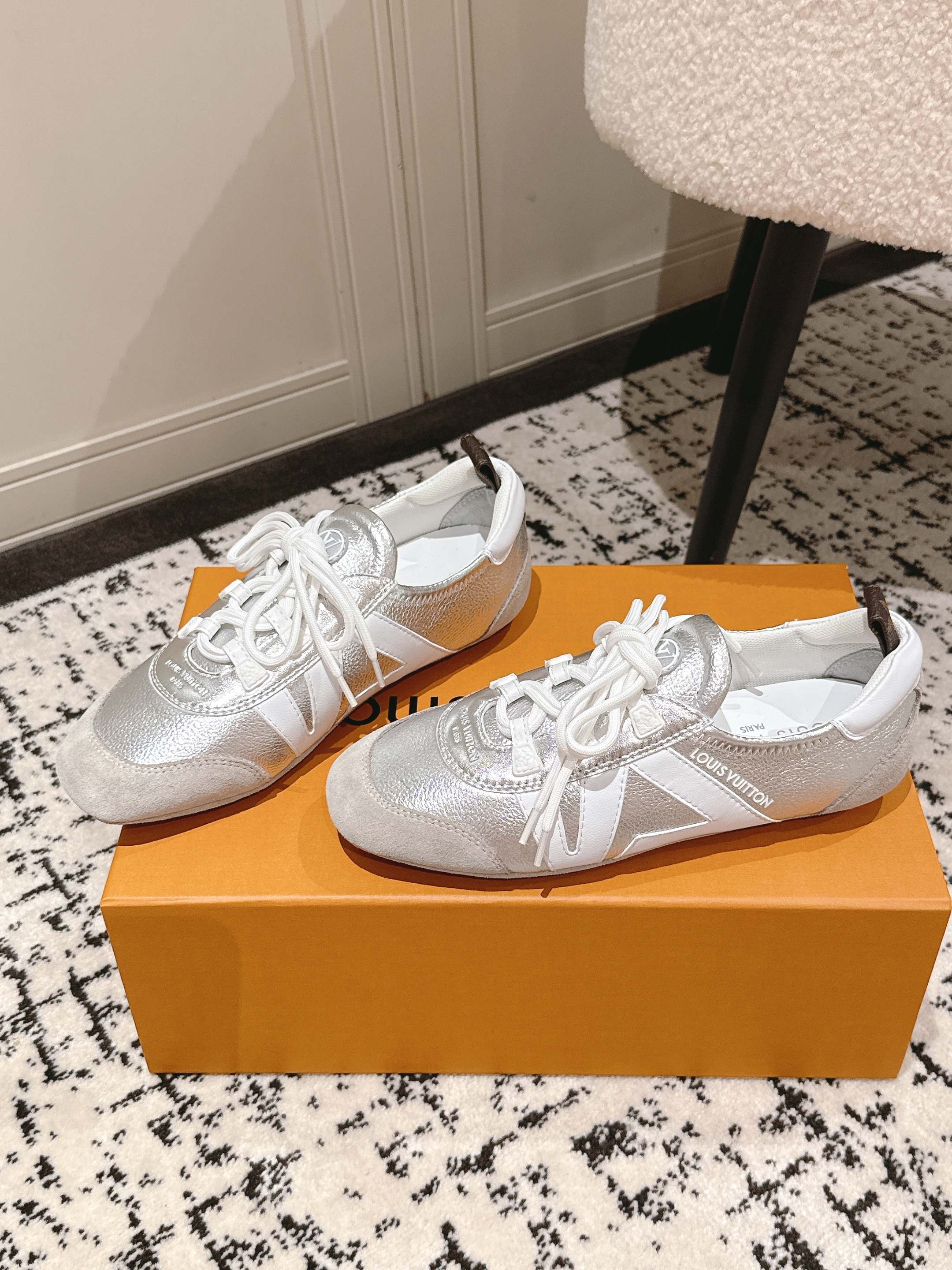 Louis Vuitton metallic silver low-top sneakers with white laces, side-by-side view