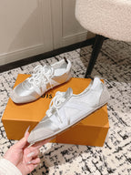 Louis Vuitton low-top sneakers, metallic silver uppers with white lace-up front