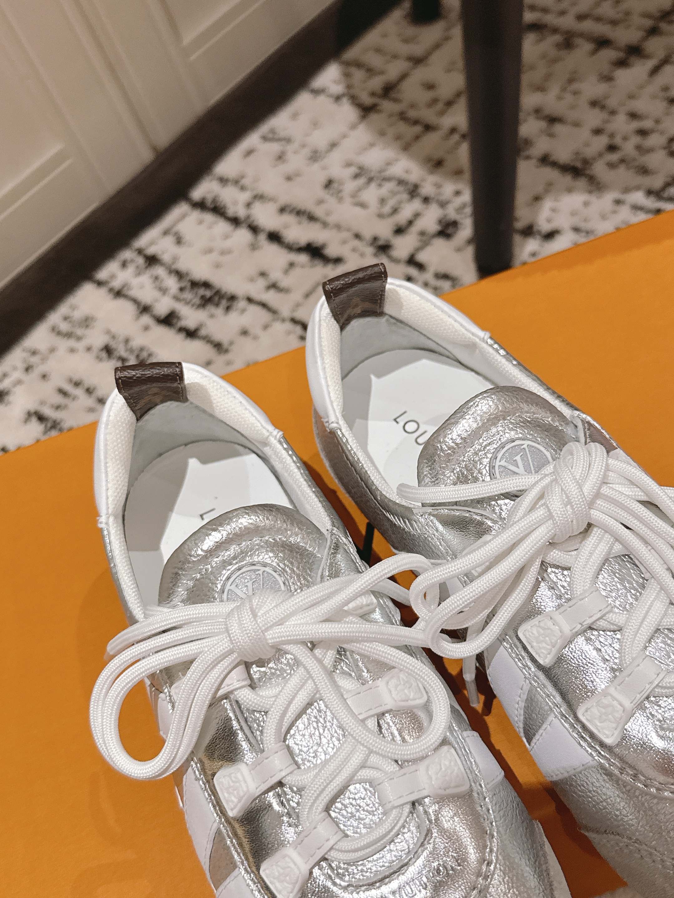 Louis Vuitton low-top sneakers with metallic silver lining and white lace-up fronts