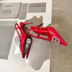 Red slingback high-heel sandals with jeweled emblem buckle on toe