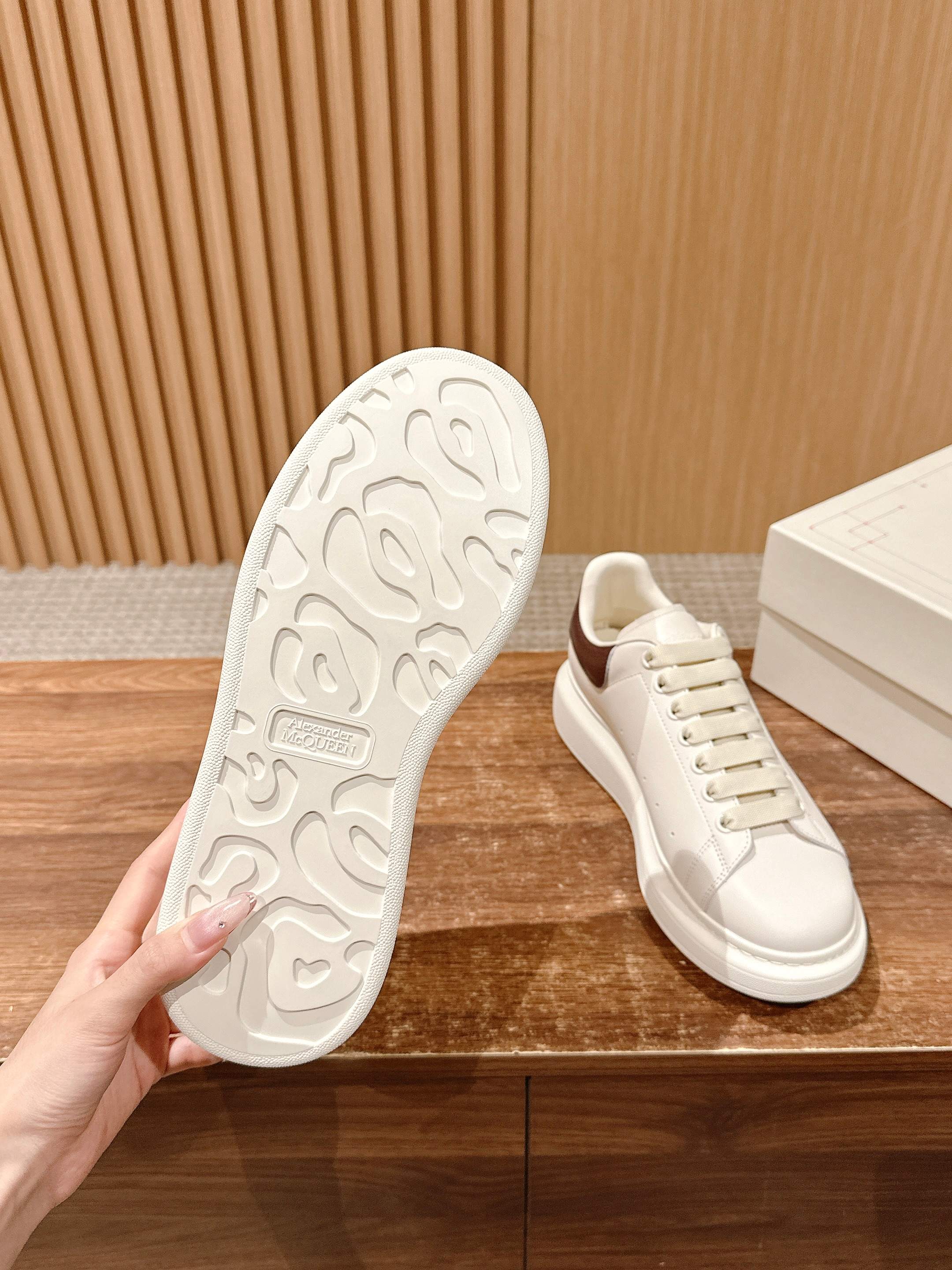 White low-top sneaker outsole with tread pattern; paired with matching lace-up upper