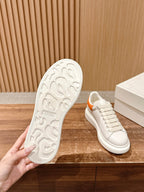 Shoe outsole and matching white sneaker with orange collar trim