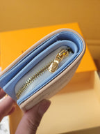Light blue mini wallet close-up showing gold zipper and soft fabric interior
