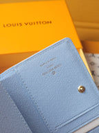 Light blue mini wallet close-up of textured fabric and gold snap button