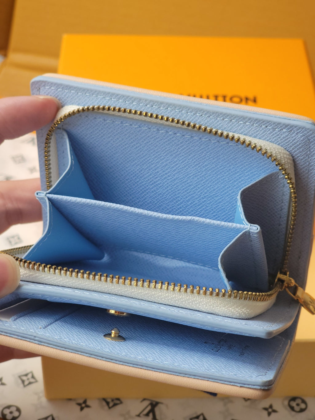 Light blue mini wallet opened view with gold zipper, card slots, and star-shaped divider