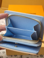 Light blue mini wallet opened view with gold zipper, card slots, and star-shaped divider