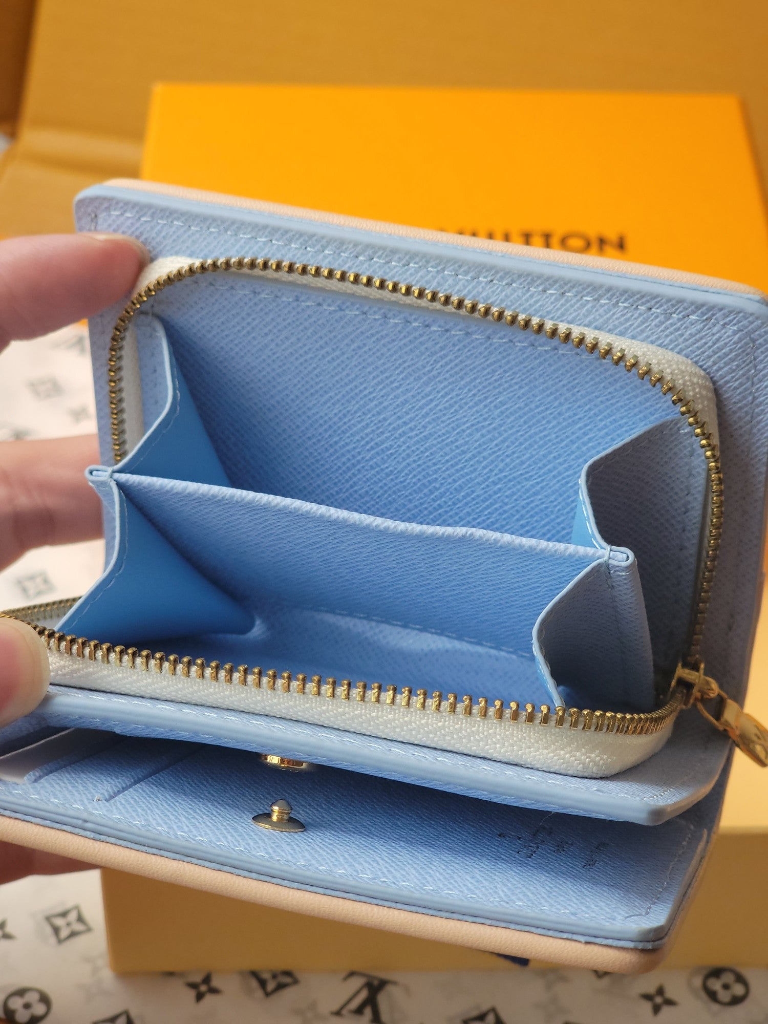Light blue mini wallet opened view with gold zipper, card slots, and star-shaped divider