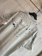 Light heather gray short-sleeve T-shirt with oval logo print and speckle splatter on chest