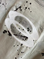 Light heather gray short-sleeve T-shirt with large oval logo and black splatter specks