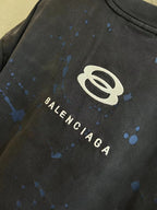Balenciaga logo T-shirt close-up with white oval mark and blue splatter details