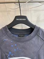 Balenciaga short-sleeve T-shirt neckline close-up, dark charcoal with blue splatter print