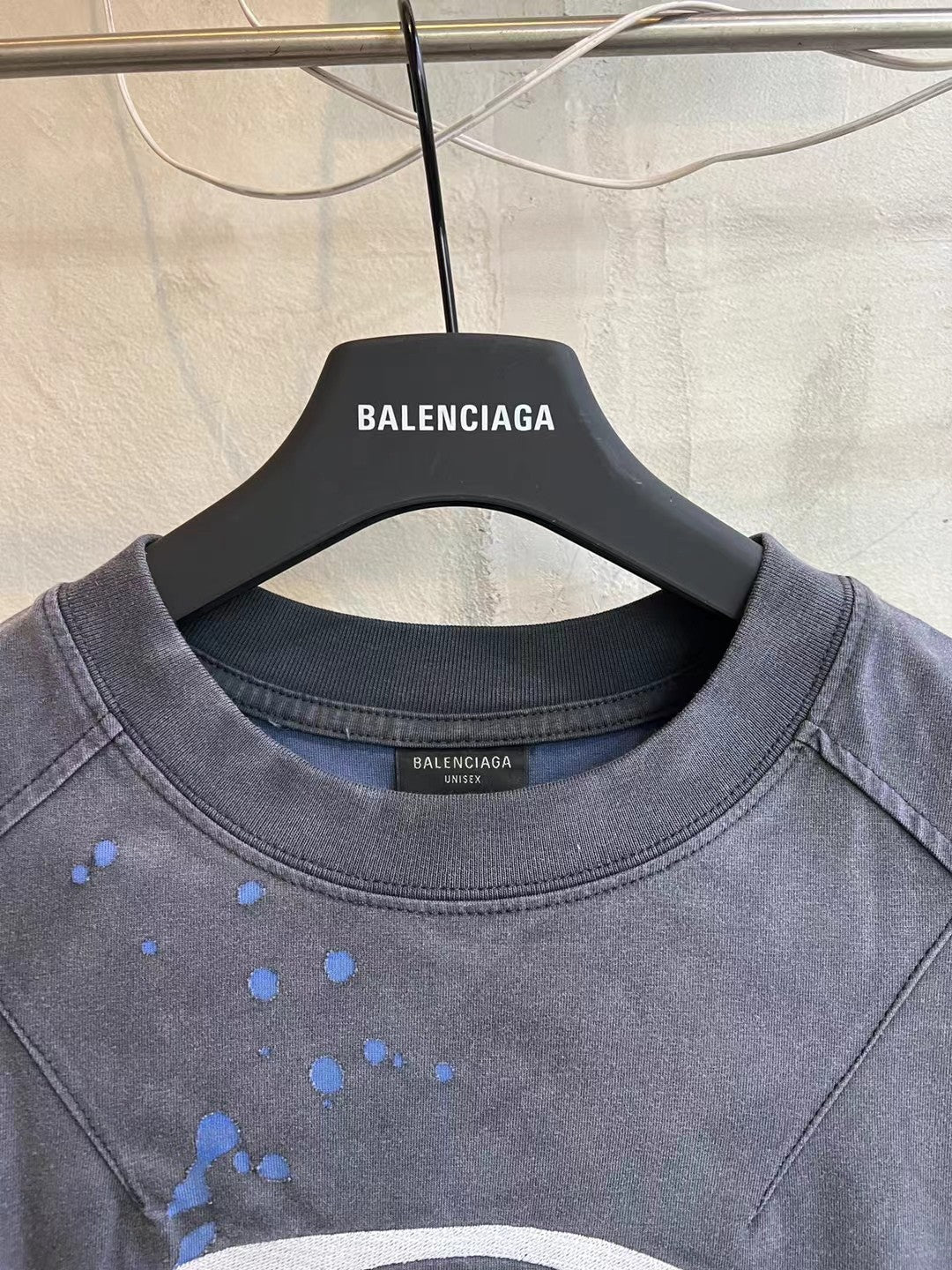 Balenciaga T-shirt neckline and chest with blue speckled splatter and white oval logo