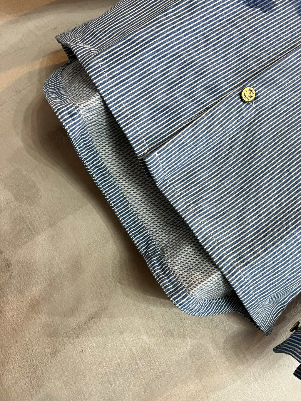 Long-sleeve shirt sleeve cuff in light blue and white stripes with gold-tone button