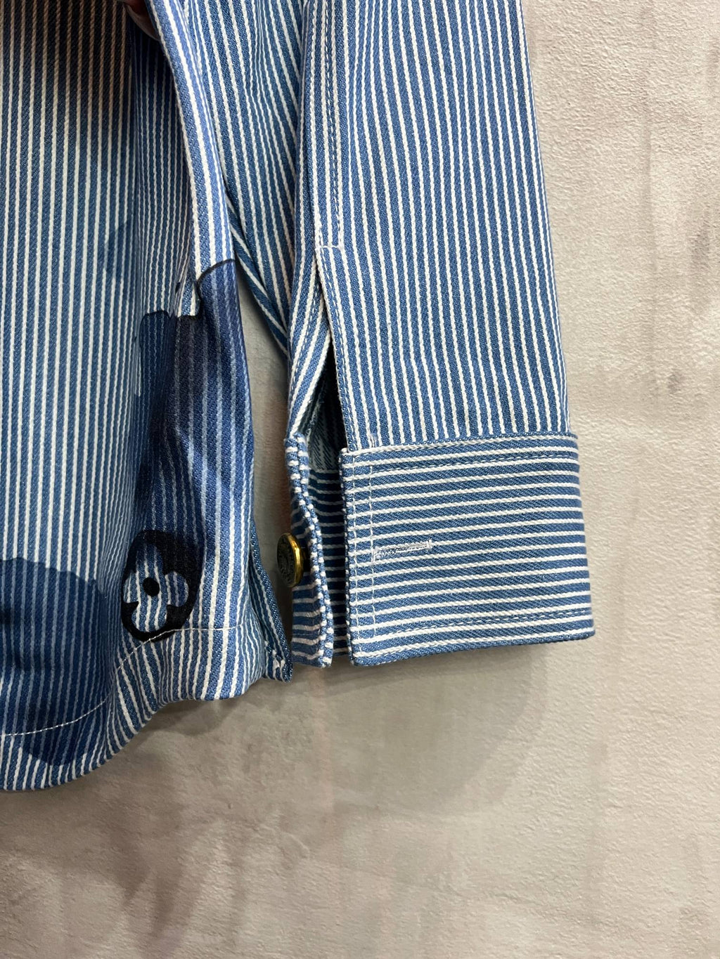 Long-sleeve shirt sleeve and cuff detail in light blue stripes with stacked button placket