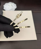 Gold-tone bangles with crystal accents on a black-gloved hand