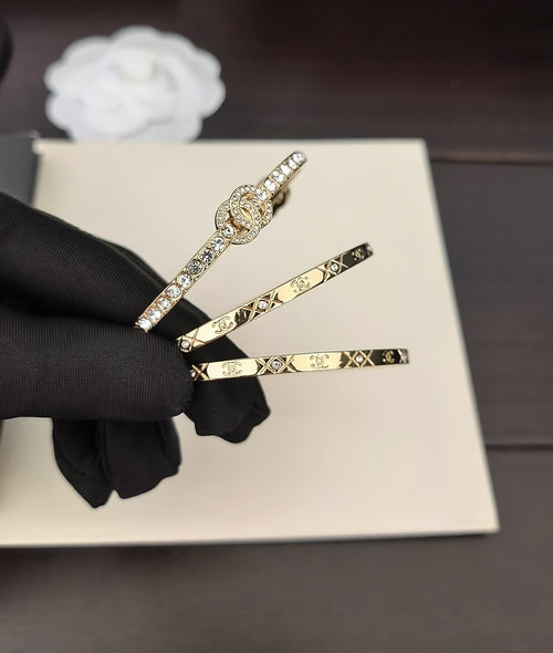 Gold-tone bangles with crystal accents on a black-gloved hand