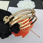 Gold-tone crystal bracelet with red-and-white enamel stripes, close-up on hand
