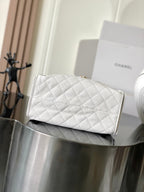 White quilted leather Chanel clutch-style bag with gold chain and stitched diamond pattern