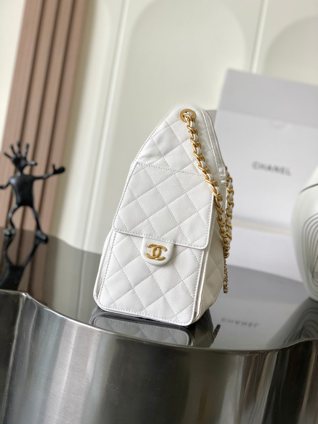 White quilted leather Chanel mini bag with gold chain strap and front flap clasp