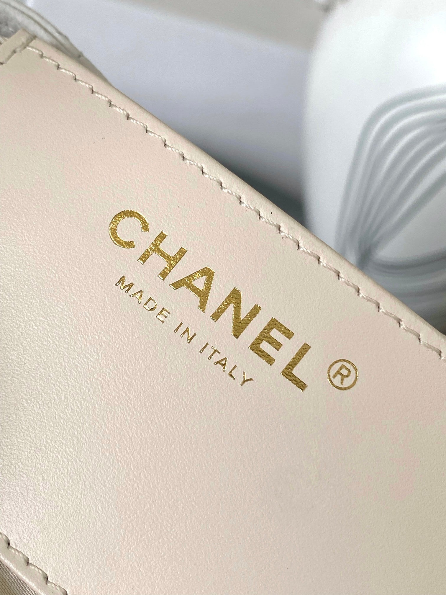White leather Chanel logo label on edge seam