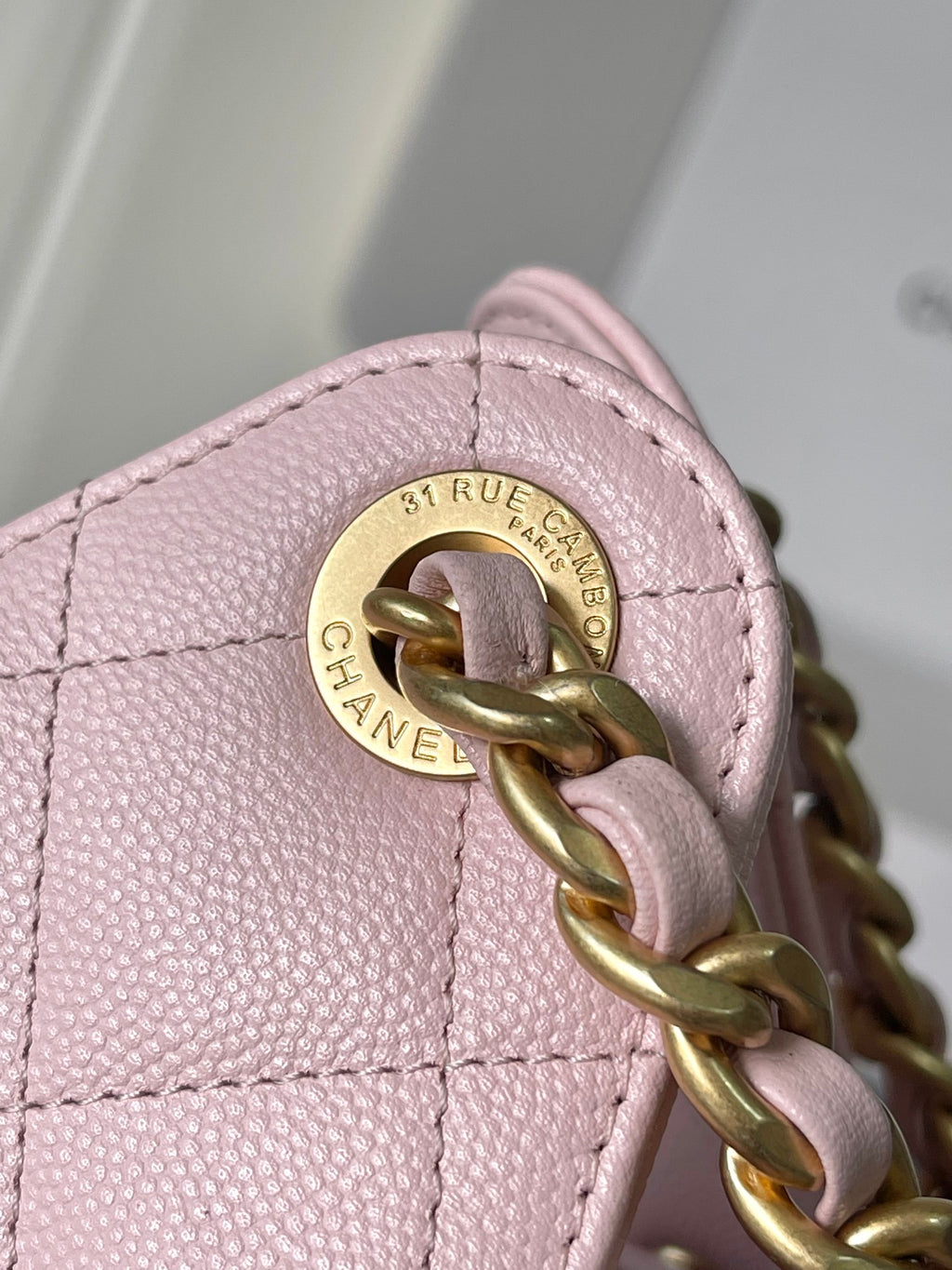 Pink quilted leather Chanel bag hardware with round turn-lock logo plate