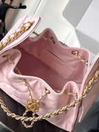 Open pink quilted Chanel bag interior with gold chain and clasp hardware