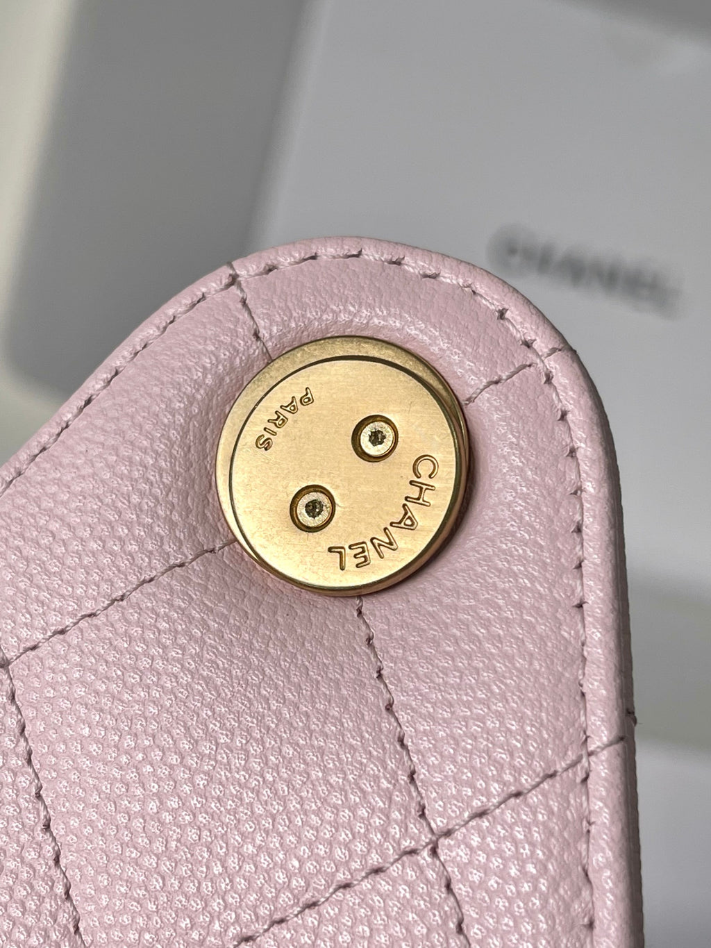 Pink leather Chanel bag turn-lock plate with CHANEL text