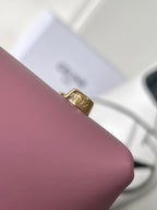 Pink leather Celine handbag close-up of gold logo hardware at strap