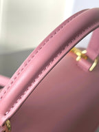 Pink leather Celine handbag close-up of top handle with stitching