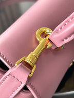 Pink leather Celine handbag close-up of gold clasp and stitched strap