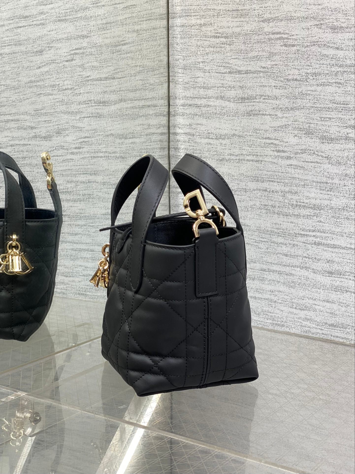 Black quilted Dior mini tote bag with short handles and gold-tone side hardware