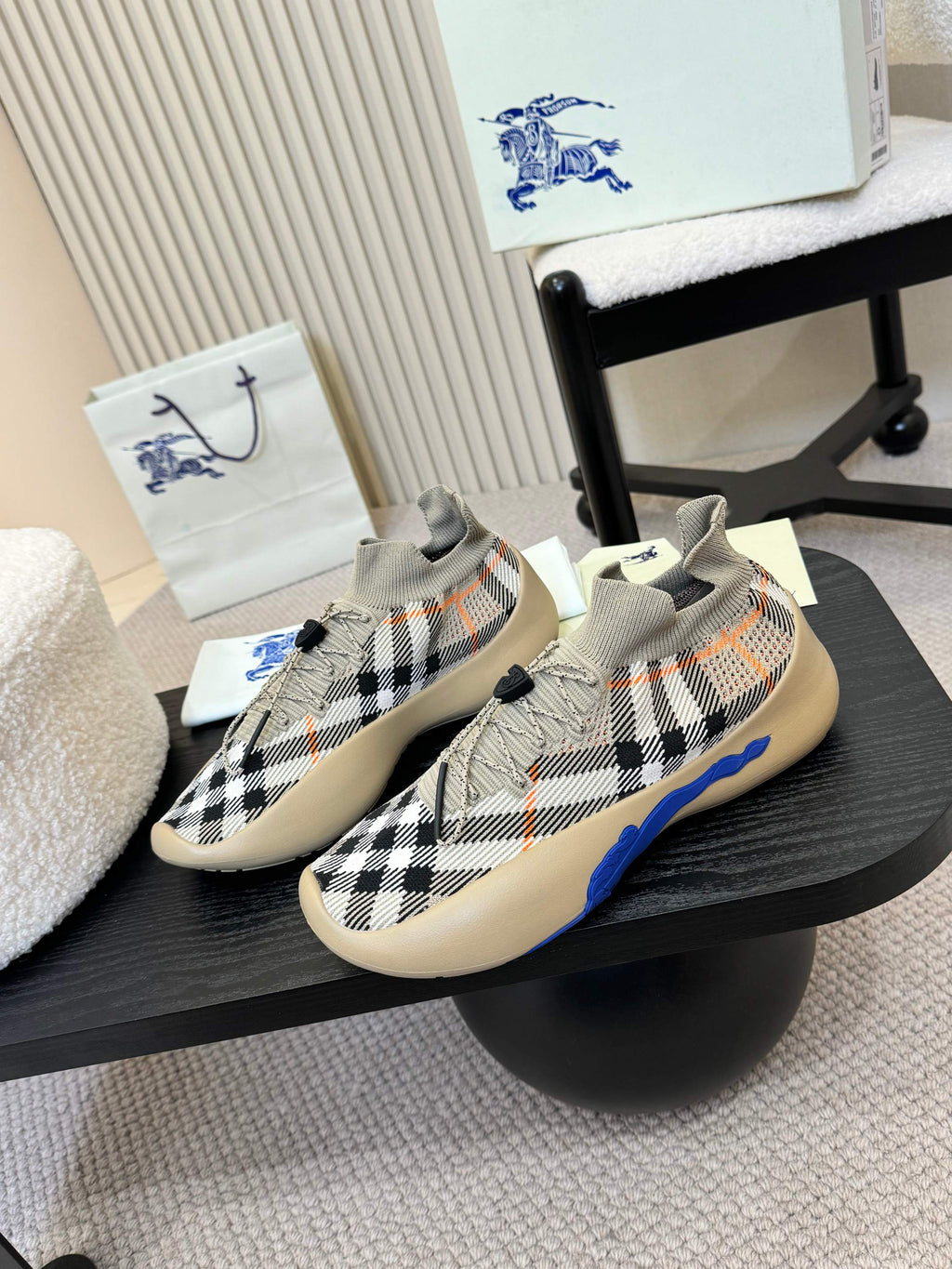 Beige and black checked slip-on sneaker with blue stripe accents and sock-like collar.