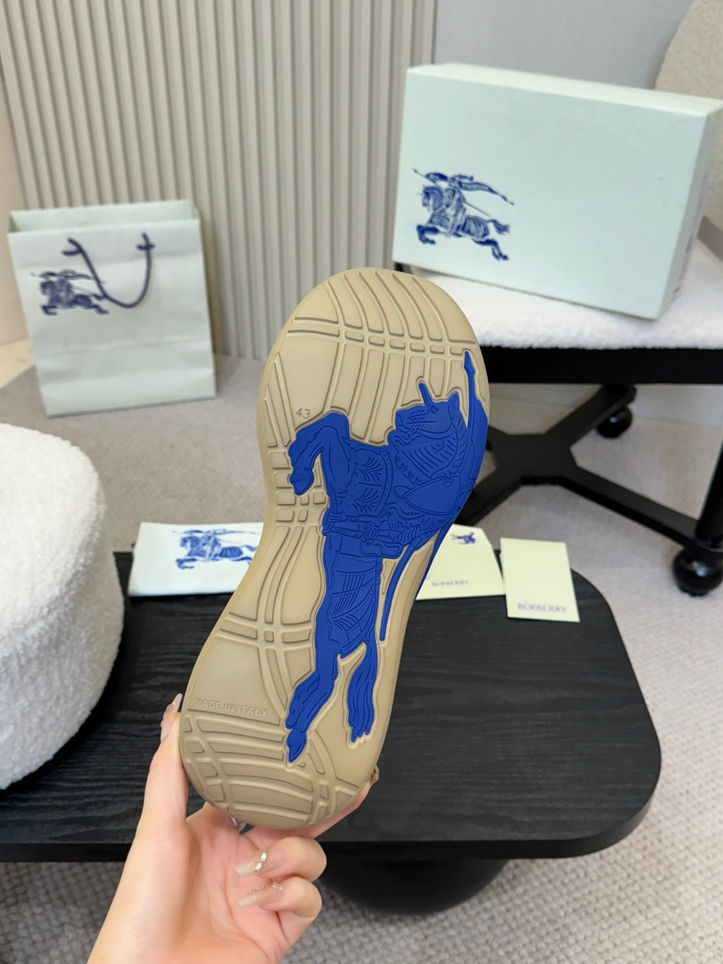 Shoe outsole of beige low-top sneaker with blue traction pattern and molded grip lines.