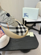 Side view of beige knit sneaker with black check pattern and blue rubber sole.