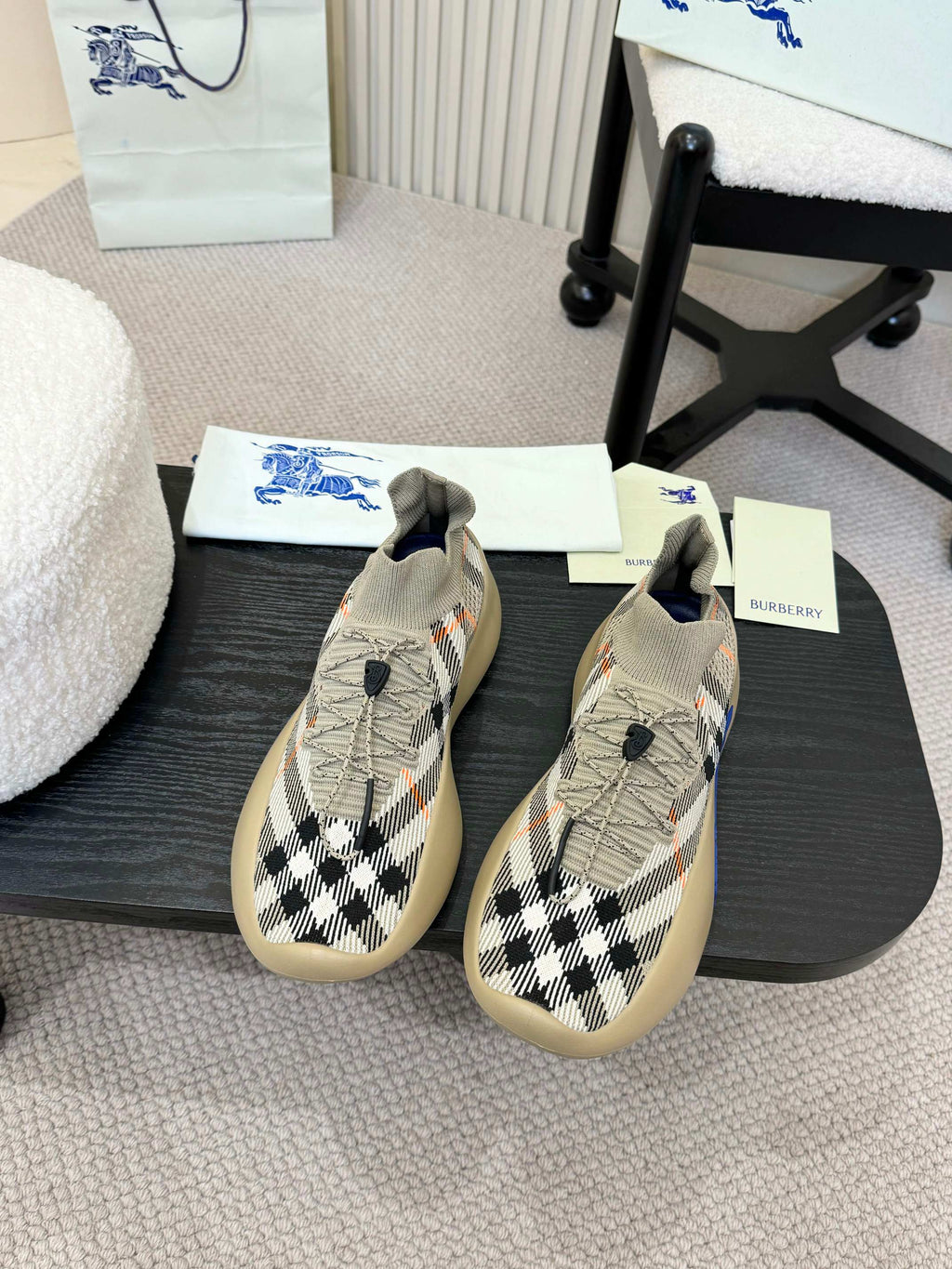 Beige slip-on sneaker with black and white check knit and blue outsole detail.