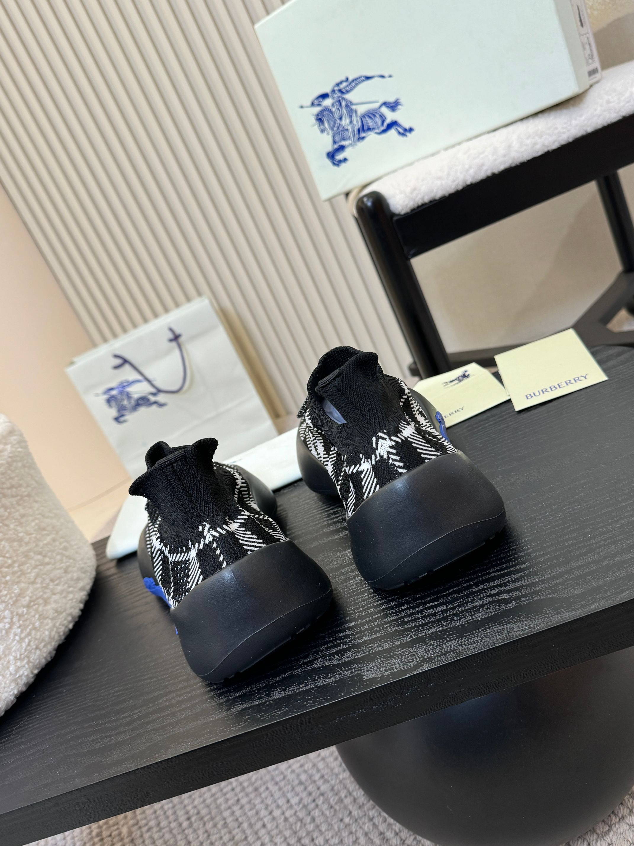 Back and side view of black check knit slip-on sneakers with blue accents