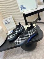 Black knit slip-on sneakers with white check pattern and blue trim on soles