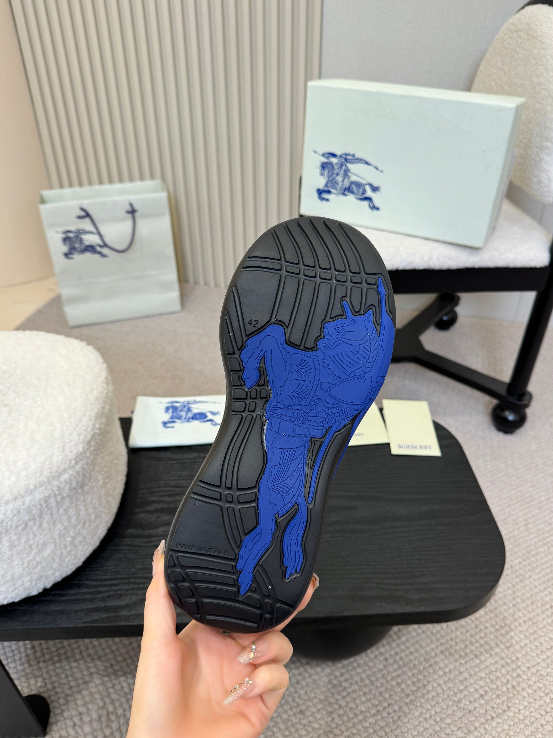 Shoe outsole view: black sole with blue traction pattern
