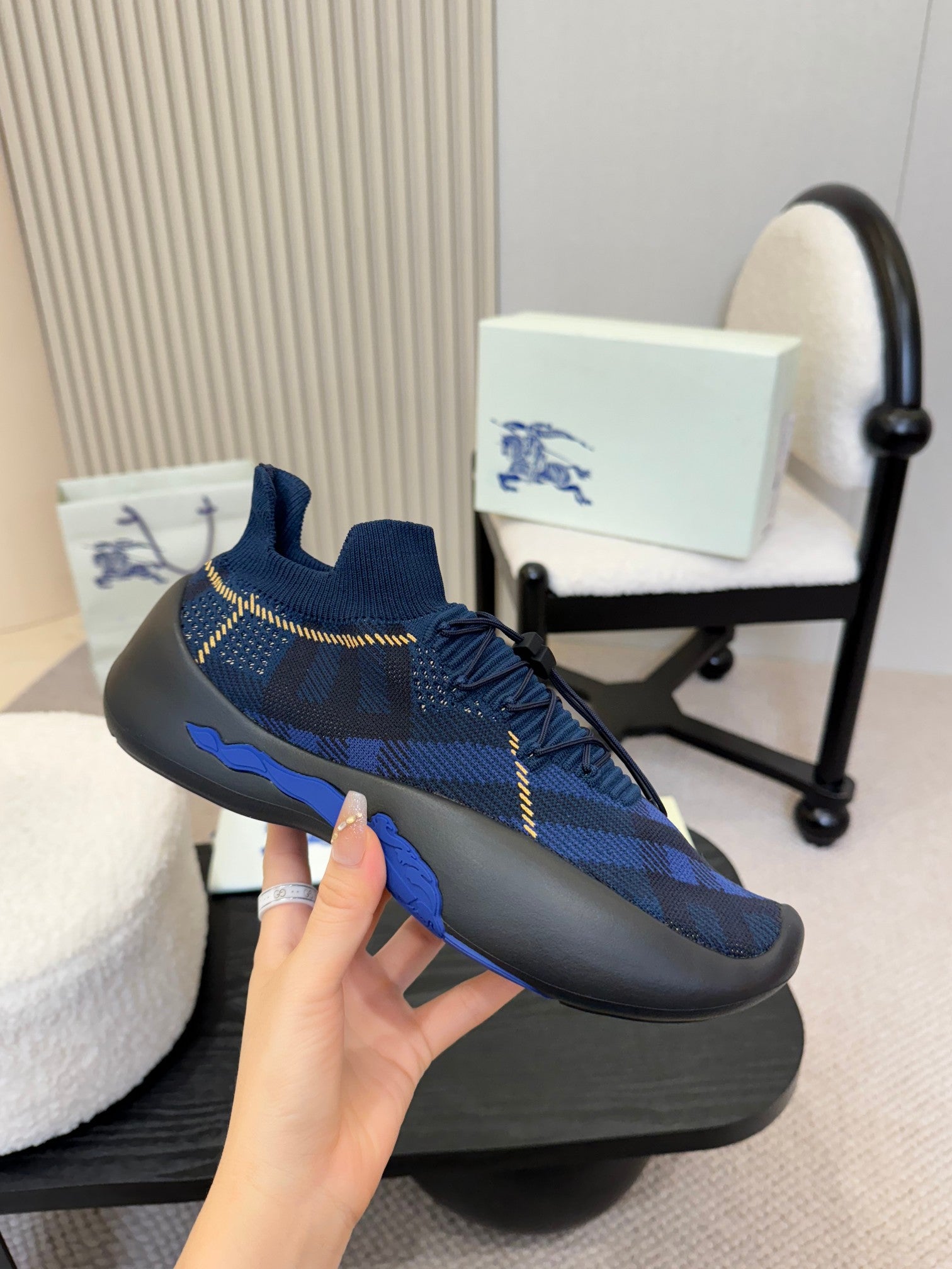 Burberry blue knit slip-on sneaker, side view, plaid pattern, yellow stitching, blue sole