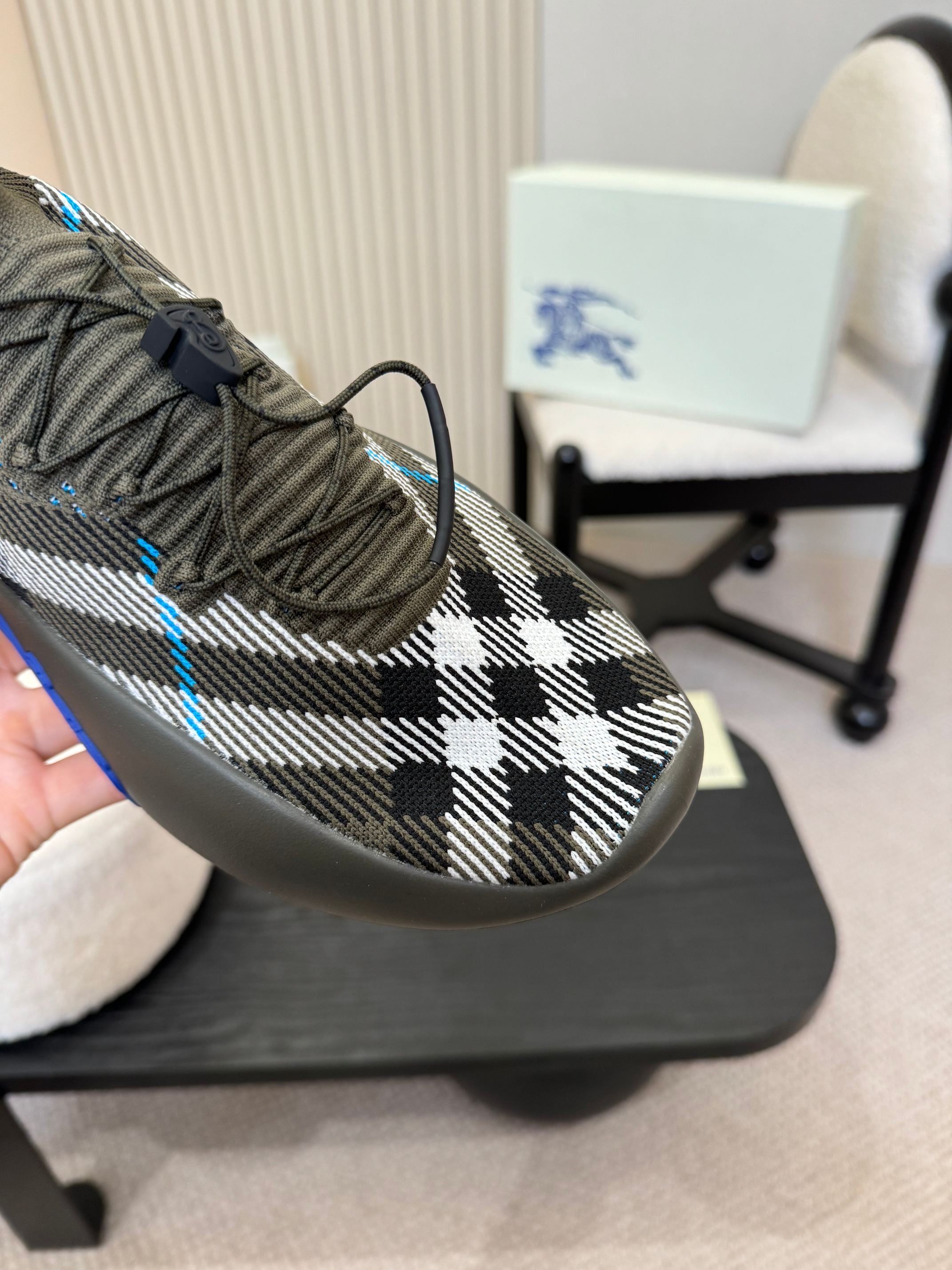 Black and white checkered knit sneaker with blue stripe on the front
