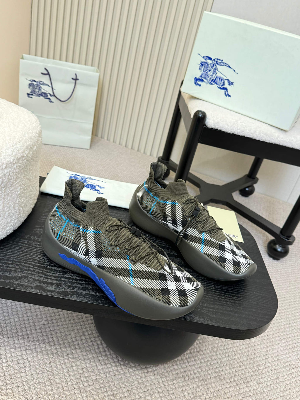 Black and white checkered knit sneaker pair with blue accents and lace-up design