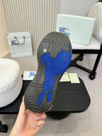 Shoe outsole with blue traction pattern on black rubber sole
