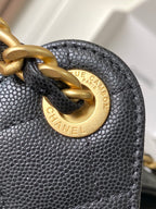 Chanel bag hardware close-up: gold ring and logo plate on dark textured leather