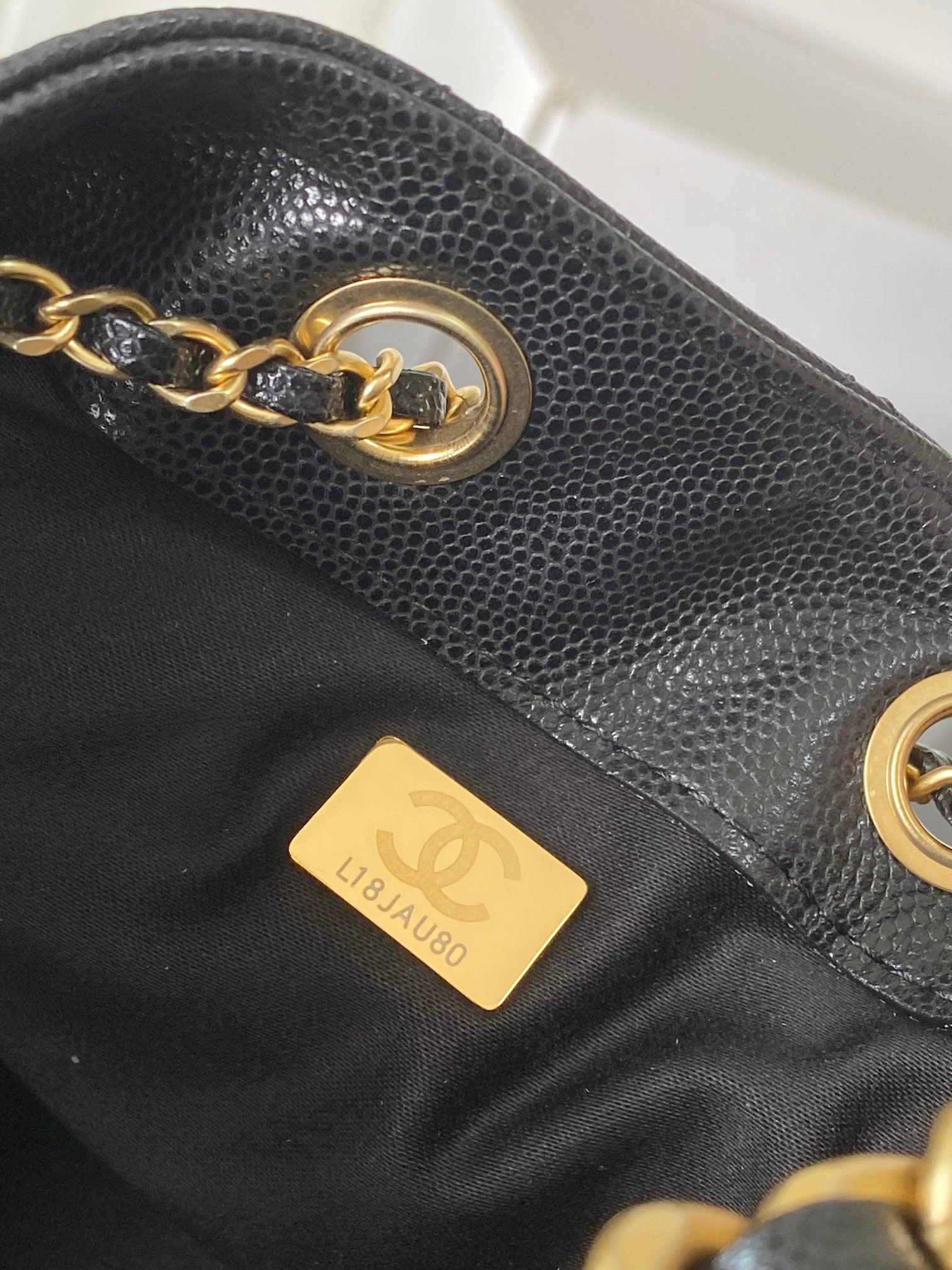 Chanel dark gray leather bag side with gold chain and gold logo plate