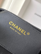Chanel bag interior branding label in gold on dark gray leather