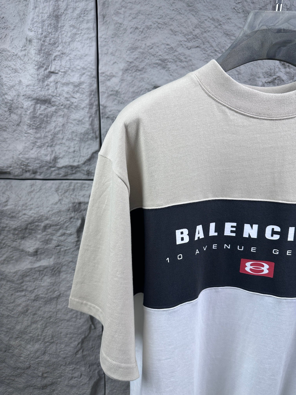 Color-block T-shirt close-up with Balenciaga print and logo patch, cream and navy
