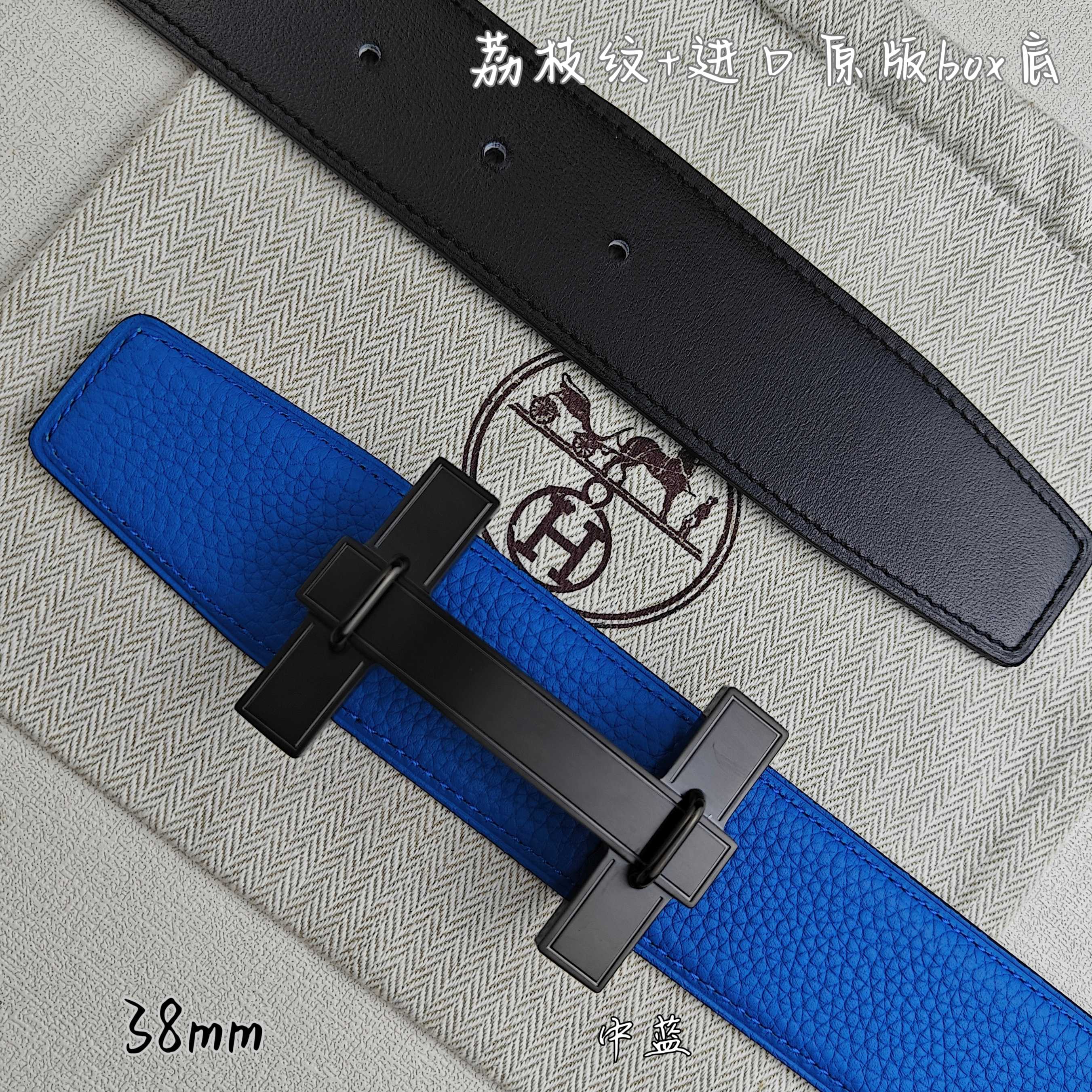 Blue Hermes belt with black buckle over; black belt lies behind.