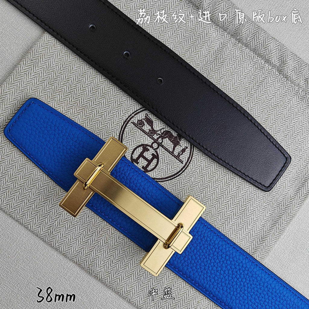 Blue Hermes belt with gold buckle over; black belt lies behind.