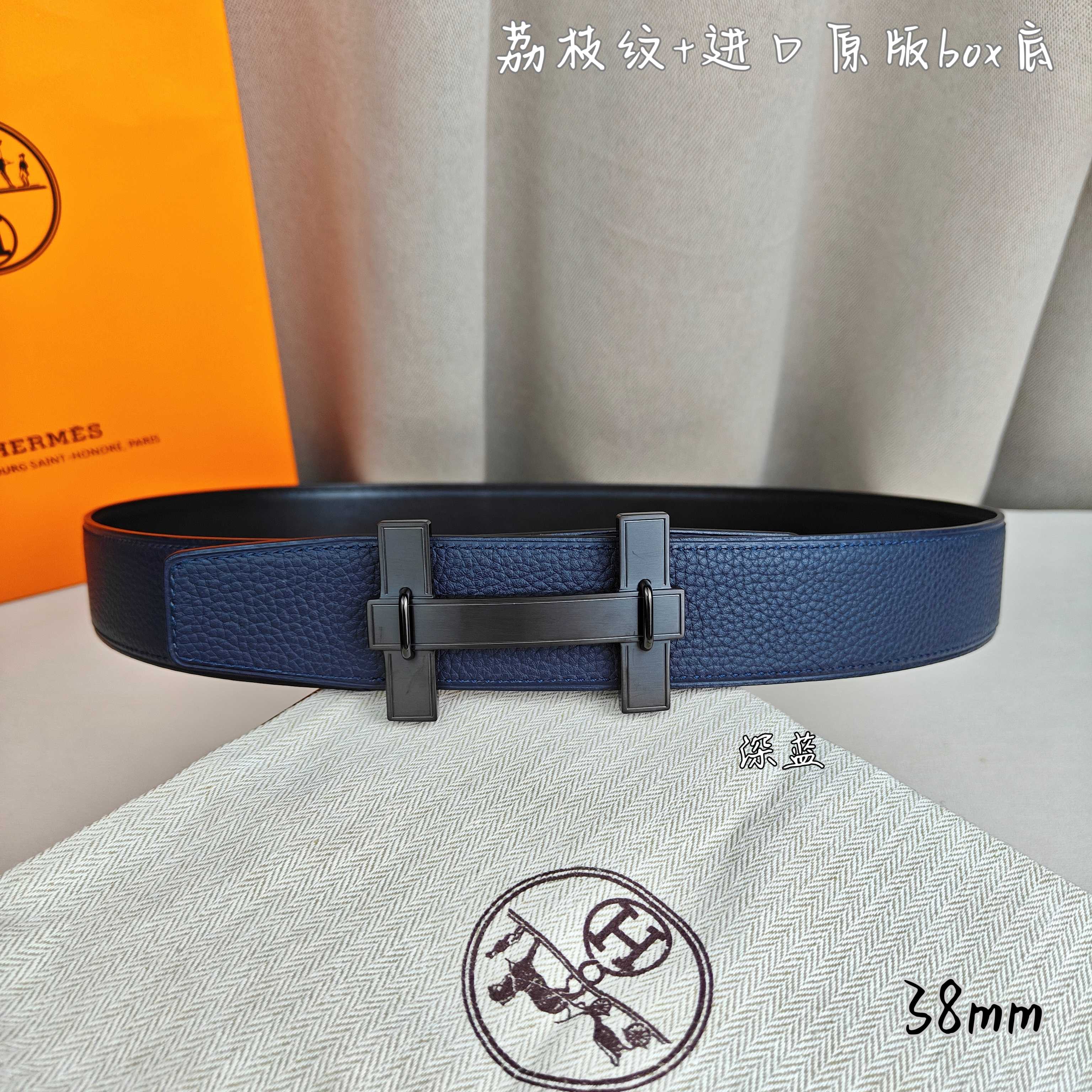 Blue leather belt with dark-gray H buckle and keeper.
